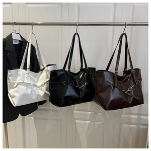 Detailed view of three large leather tote bags in cream, black, and brown for business commute