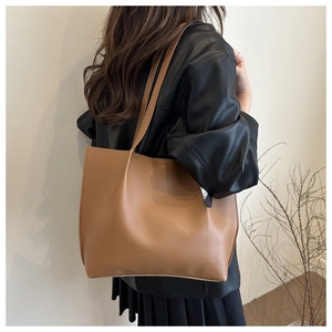Rear view of a camel large tote bag on model showing size and matte leather texture