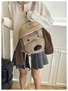 Detail of cute puppy corduroy backpack with striped flap and long brown ears