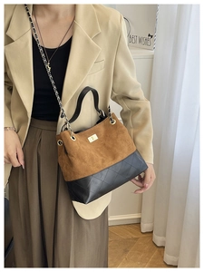 Brown suede and black leather quilted tote bag with gold chain strap on model