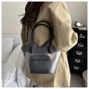 Détail d'un grand sac cabas noir mat avec pochette porté à l'épaule par un mannequin
