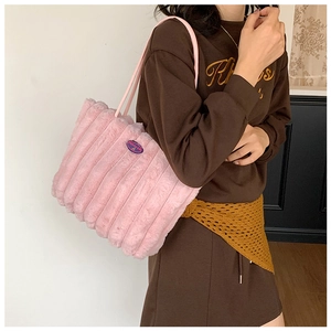 Detail of pink faux fur tote bag with vertical stripes and slim shoulder straps