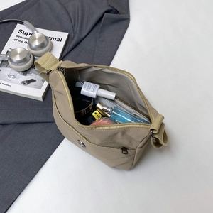 Khaki nylon crossbody bag with spacious interior for cosmetics and daily commute items