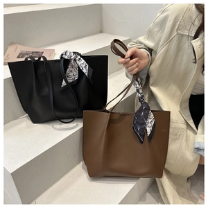 Detail of vintage tote bags in black and coffee leather with decorative silk scarves
