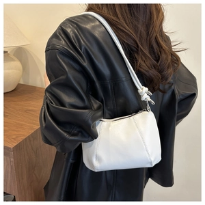 Back view of model wearing a white minimalist underarm bag with knot detail
