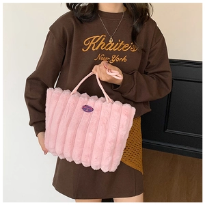 Detail of pink faux fur tote bag showing vertical quilted texture and brand label