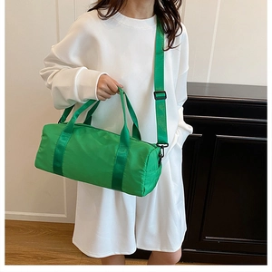Detail of a bright green cylinder sports bag with adjustable straps for gym and travel