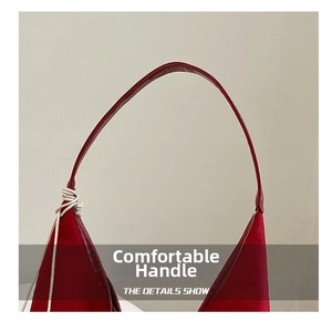Detail of red canvas tote bag featuring sturdy faux leather handles and white rope knot