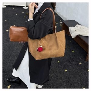 Brown frosted tote bag with matching pouch and decorative pompom on a model
