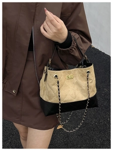 Detail of color-block tote bag featuring quilted patterns and gold chain shoulder strap