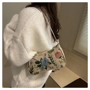 Detail of floral tapestry underarm bag with beige leather trim and vintage flower pattern
