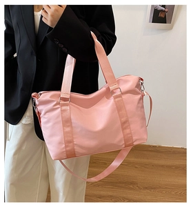 Pink waterproof nylon travel bag with dual handles and adjustable shoulder strap for gym