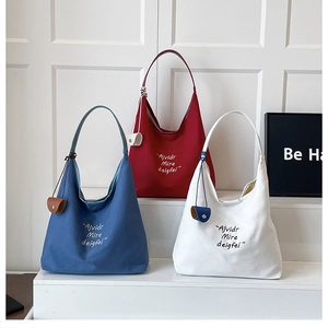 Three minimalist large canvas tote bags in red, blue, and white with decorative mini pouches