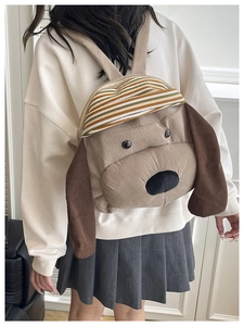 Detail of dog-shaped corduroy backpack showing color-block stripes and floppy ears