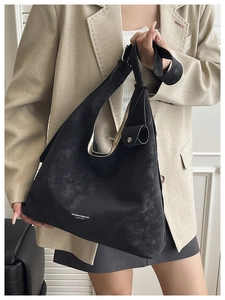 Detail of a black matte hobo bag with adjustable wide strap and branded print