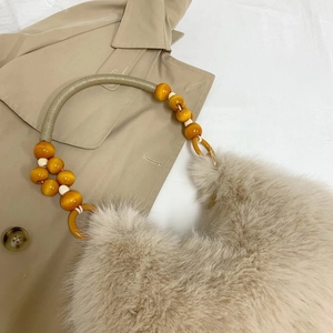 Plush beige faux fur handbag with oversized yellow wooden beads and metal handle