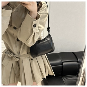 Mirror selfie showing a black pebble leather shoulder bag with knotted strap detail