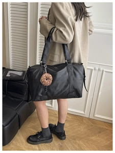 Détail du sac cabas noir en cuir PU avec motif litchi et breloque beignet peluche