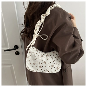 Detail of corduroy crescent bag with heart prints and ruffled shoulder strap