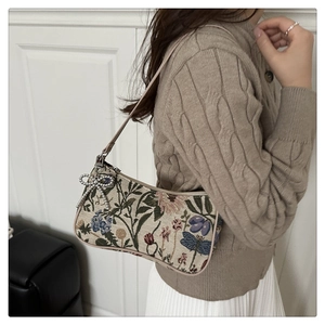 Detailed view of jacquard floral bag with dragonfly patterns and rhinestone butterfly charm