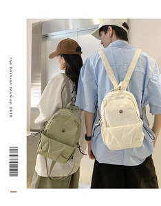 Dual view of nylon backpacks in sage green and cream with multi-pocket design