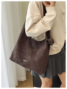 Detail of vintage dark brown tote bag with white lettering on premium matte texture
