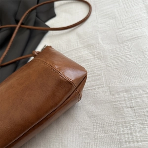 Brown vintage faux leather shoulder bag with sleek texture and precise stitching