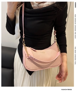 Detailed view of pink woven half-moon bag featuring gold chain and leather strap