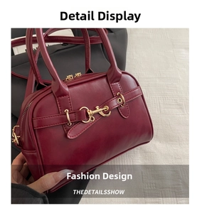 Close-up of wine red PU leather handbag with gold metal hardware and zip closure details