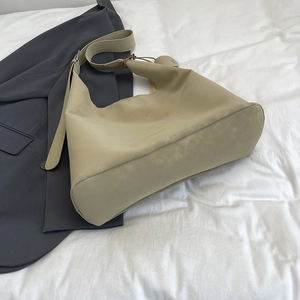 Minimalist large khaki leather tote bag shown with a stylish dark grey office blazer