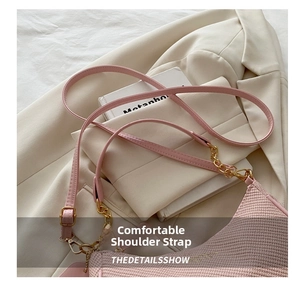 Detailed close-up of pink woven texture on handbag with elegant gold chain hardware