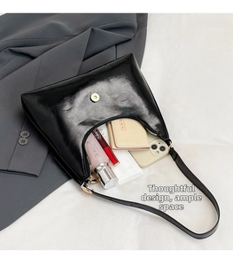 Close-up of black glossy bucket bag interior showing large capacity for essentials