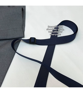 Detail of adjustable dark blue nylon shoulder strap with a matte black plastic buckle