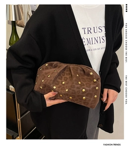 Dettaglio della borsa leopardata con borchie dorate a fungo e design a nuvola pieghettata