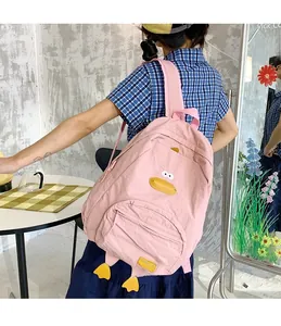 Detail view of pink cartoon duck backpack with yellow feet and adjustable straps