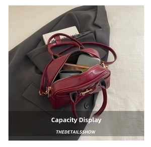 Detail showing internal capacity of the burgundy leather boston bag with accessories