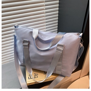 Macro view of lavender nylon travel bag detail showing smooth fabric and metal strap buckle