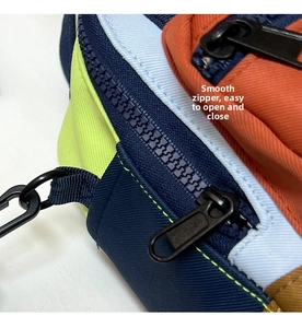 Macro detail of smooth durable zipper and color-block nylon fabric on casual handbag