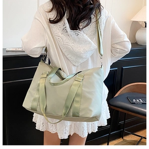 Detailed back view of a mint green large capacity shoulder bag on a model