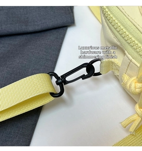 Detail of the durable matte black metal hook and yellow strap on this canvas bag