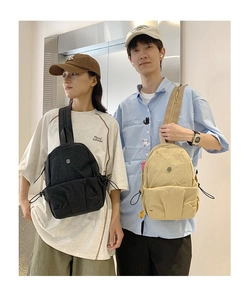 Waterproof nylon crossbody bag with drawstring pocket in black and beige lifestyle view