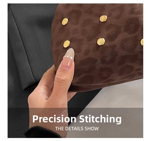 Dettaglio della pochette marrone con rilievo leopardato, borchie d'oro e cuciture