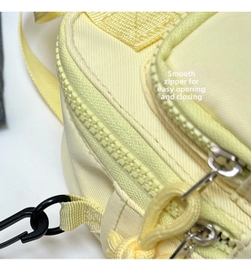 Detail of yellow nylon bag showing smooth double zipper closure and black plastic hooks