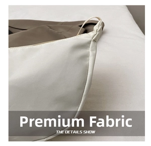 Detail shot of the cream nylon dumpling bag featuring high-density fabric texture
