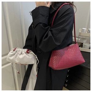 Detail of woven leather shoulder bag in burgundy with inner grey drawstring pouch