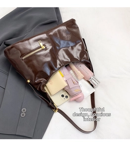 Innenansicht der großen glänzenden braunen Umhängetasche mit Schirm und Kosmetik
