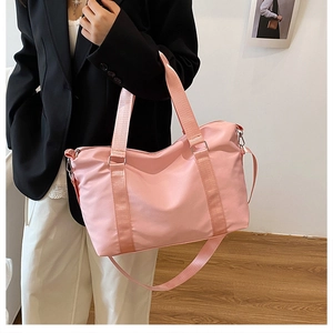 Pink large capacity travel bag worn over the shoulder showing actual size on a person
