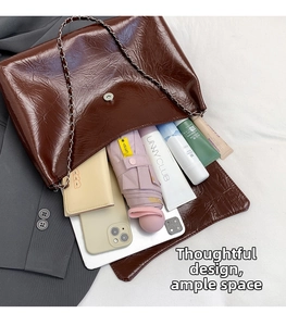 Détail de l'intérieur spacieux du sac à chaîne en cuir marron avec des objets du quotidien