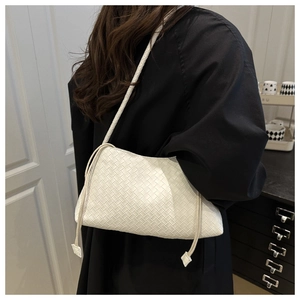 Dettaglio della borsa hobo bianca intrecciata che mostra la trama in pelle e coulisse