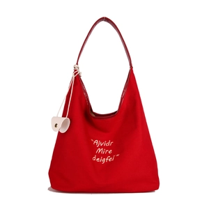 Minimalist red canvas tote bag with shoulder straps and white decorative charms